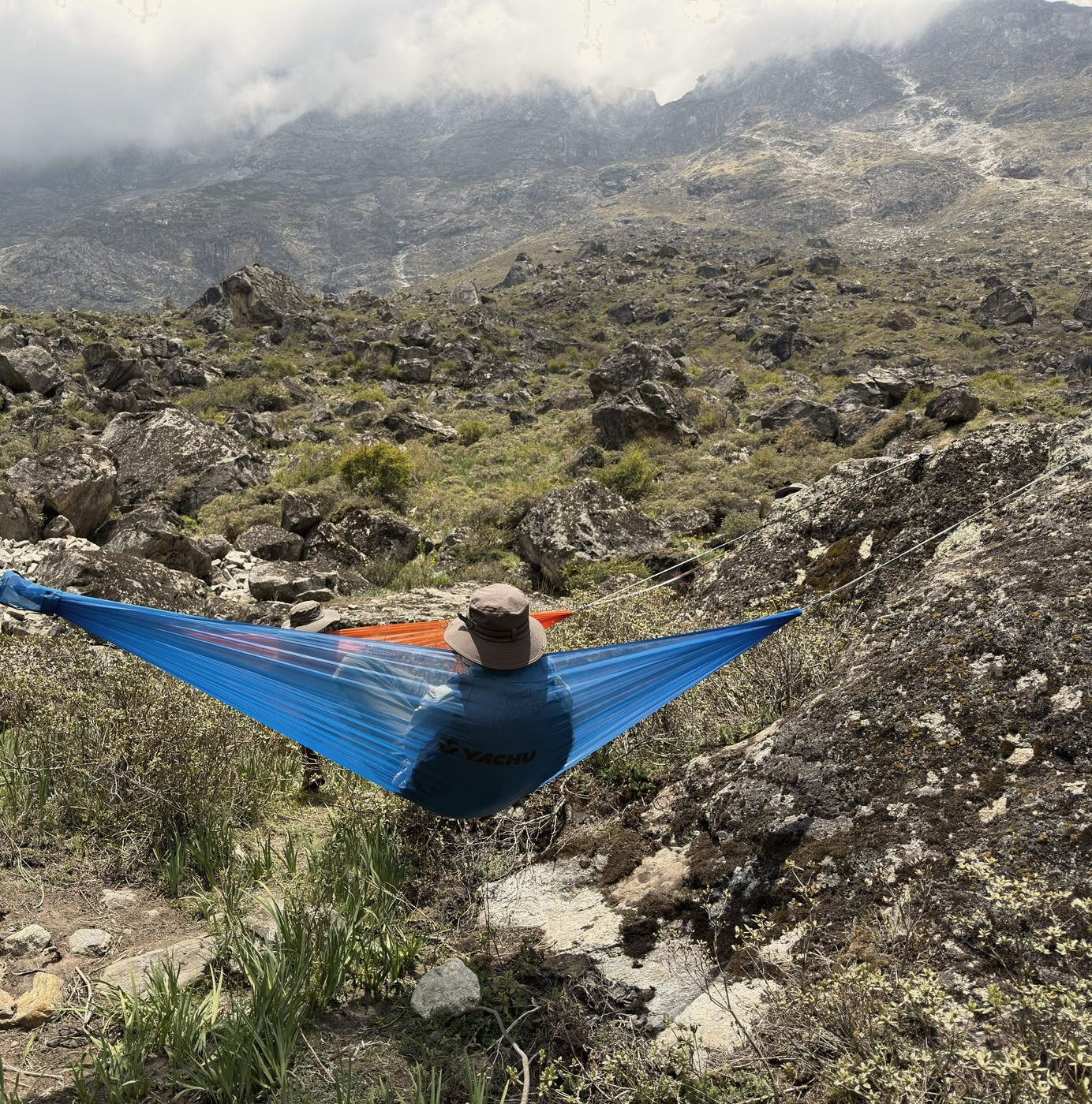 The blue Airlite Hammock slung between boulders in Langtang